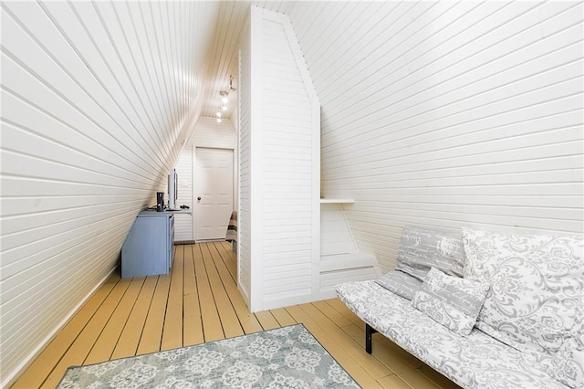 additional living space featuring light wood-type flooring and lofted ceiling