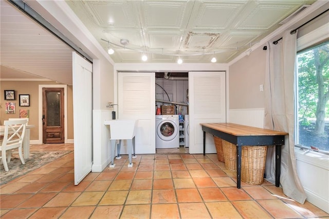 clothes washing area featuring crown molding, separate washer and dryer, and light tile patterned flooring