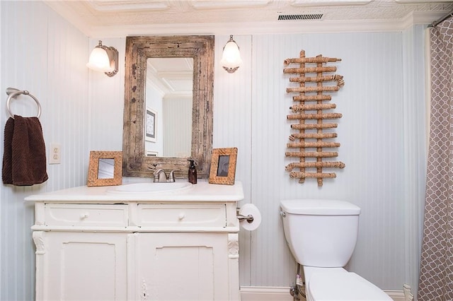 bathroom with ornamental molding, vanity, and toilet