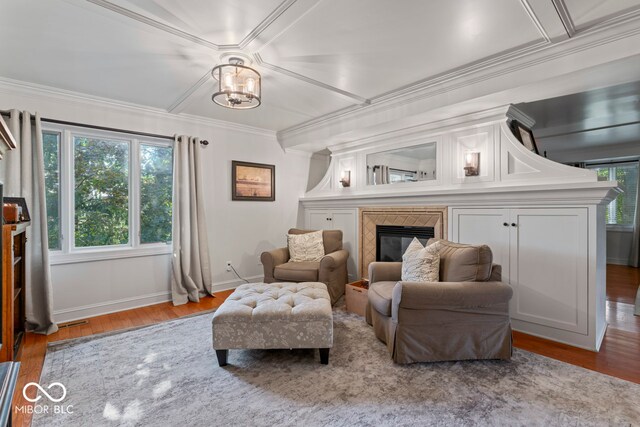 living area with an inviting chandelier, light wood-type flooring, and ornamental molding