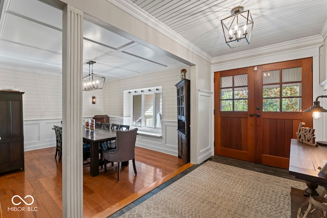 entrance foyer with a notable chandelier, crown molding, and hardwood / wood-style floors