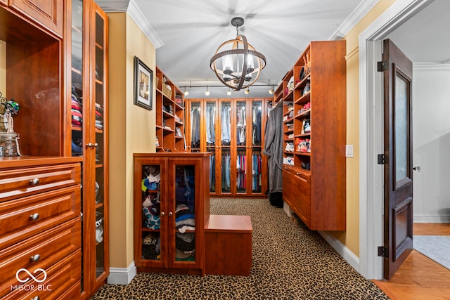 walk in closet featuring a notable chandelier and hardwood / wood-style floors