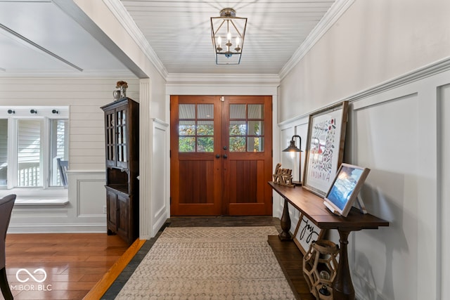 foyer with crown molding, an inviting chandelier, french doors, and hardwood / wood-style flooring