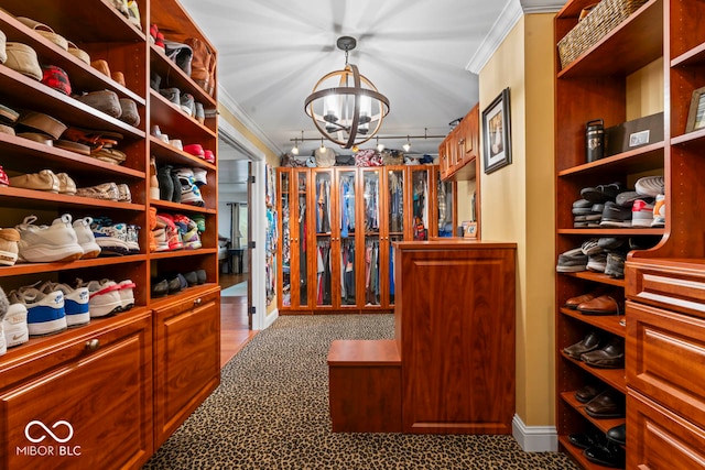 walk in closet featuring a notable chandelier