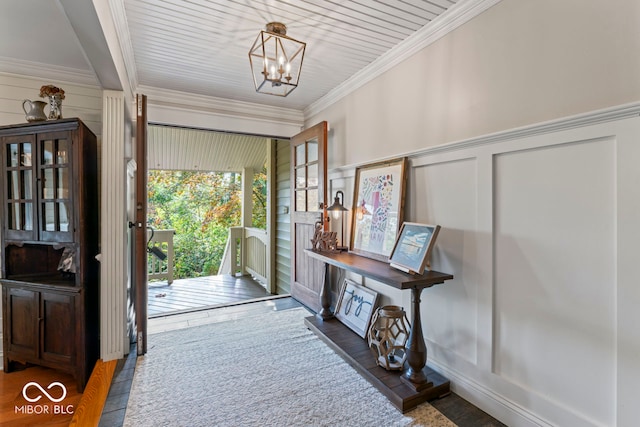 entrance foyer featuring ornamental molding, dark hardwood / wood-style flooring, and a chandelier