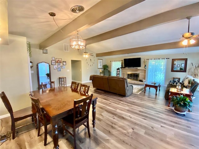 dining room featuring hardwood / wood-style flooring, ceiling fan with notable chandelier, and beam ceiling