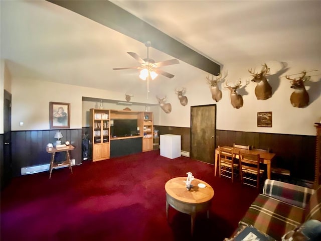 carpeted living room with ceiling fan and beam ceiling