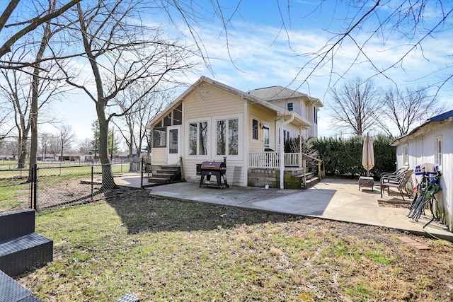 rear view of property with a yard and a patio area