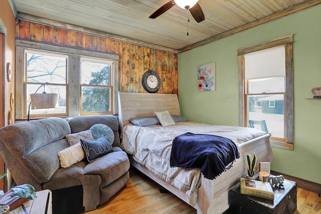 bedroom featuring wood ceiling, wood walls, ceiling fan, and light hardwood / wood-style flooring