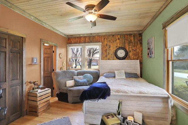 bedroom with wooden walls, ceiling fan, wood ceiling, and light wood-type flooring