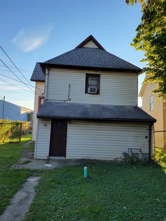 back of property with cooling unit and a lawn