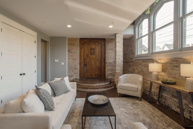 living room featuring brick wall, dark hardwood / wood-style floors, and ornate columns