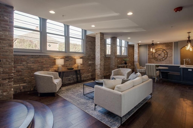 interior space featuring brick wall, dark wood-type flooring, and a healthy amount of sunlight