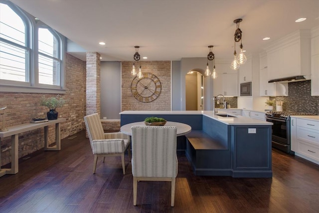 kitchen with a kitchen island with sink, white cabinetry, sink, and stainless steel appliances