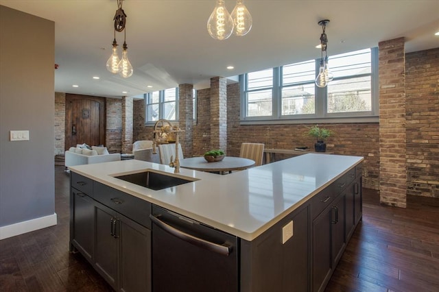 kitchen with stainless steel dishwasher, hanging light fixtures, sink, a chandelier, and a kitchen island with sink