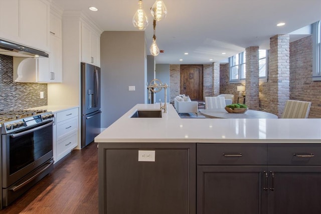 kitchen featuring pendant lighting, white cabinets, appliances with stainless steel finishes, and dark wood-type flooring