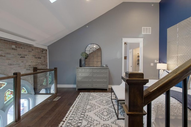 corridor featuring high vaulted ceiling and dark hardwood / wood-style floors