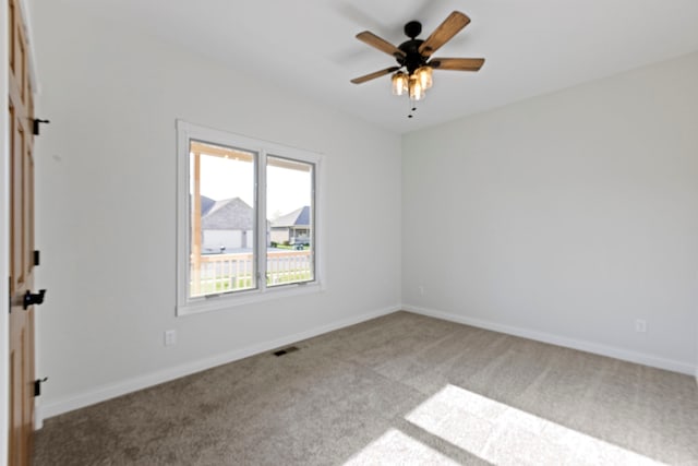 carpeted spare room with ceiling fan