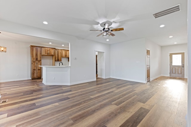 unfurnished living room featuring hardwood / wood-style flooring and ceiling fan