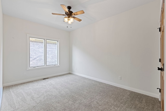 spare room with ceiling fan and carpet