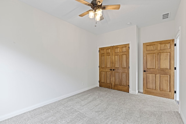 unfurnished bedroom featuring a closet, ceiling fan, and carpet