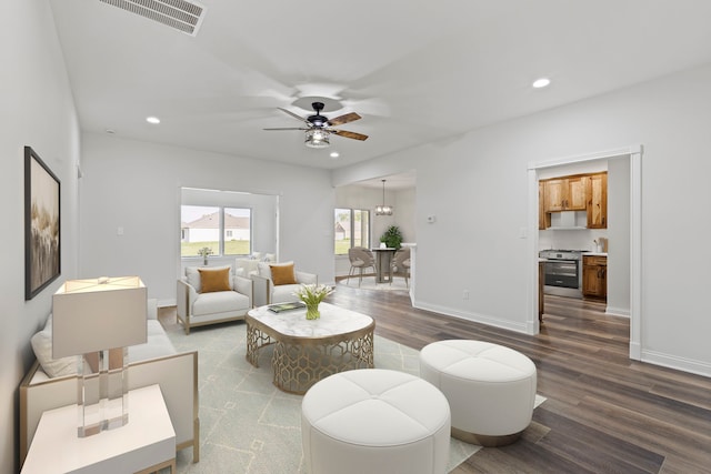 living room with ceiling fan and dark wood-type flooring