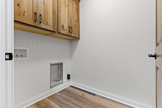 laundry area featuring hookup for a washing machine, wood-type flooring, and cabinets