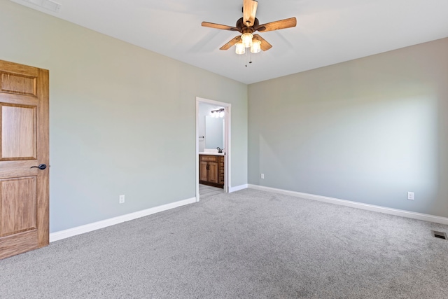 unfurnished bedroom with ensuite bath, ceiling fan, and carpet flooring