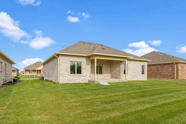 rear view of house featuring a patio area, a yard, and central AC unit