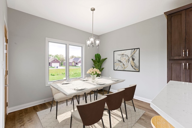 dining space featuring hardwood / wood-style flooring and a chandelier