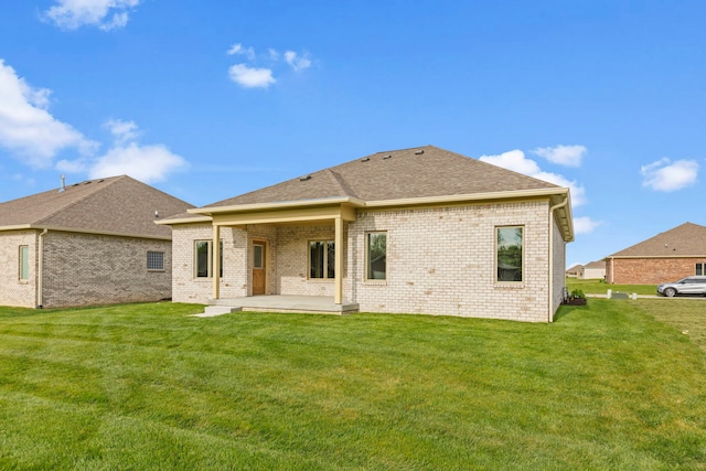 rear view of house with a patio and a yard