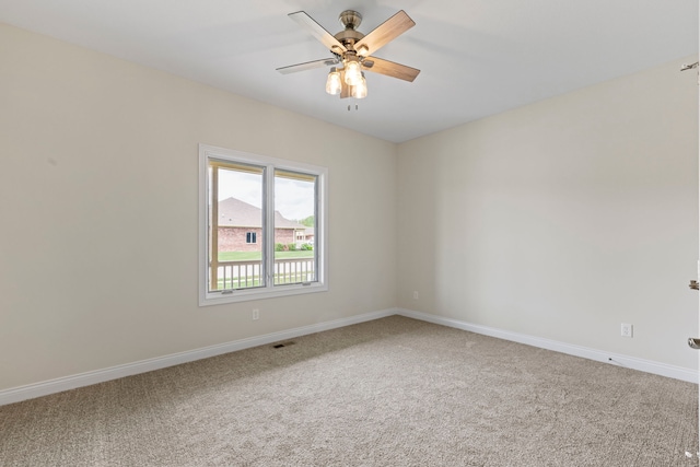 carpeted spare room featuring ceiling fan