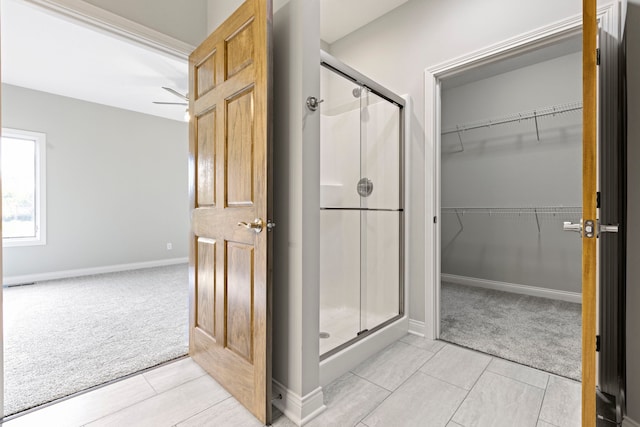 bathroom featuring a shower with door and tile flooring