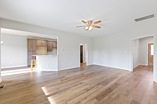 unfurnished room featuring sink, ceiling fan, and hardwood / wood-style floors