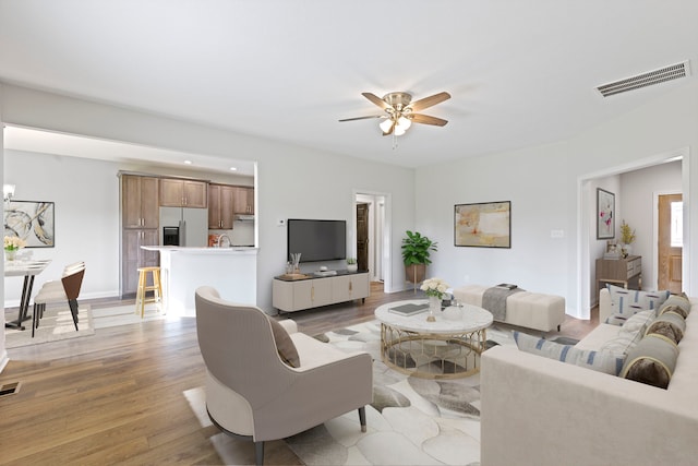 living room with light hardwood / wood-style flooring and ceiling fan