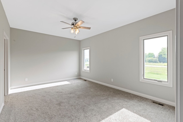 carpeted spare room with a healthy amount of sunlight and ceiling fan