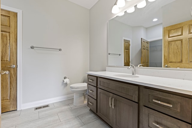 bathroom featuring toilet, tile floors, and vanity