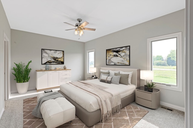 bedroom with light colored carpet, ceiling fan, and multiple windows