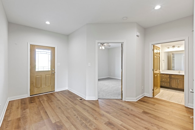 entrance foyer with light carpet and ceiling fan