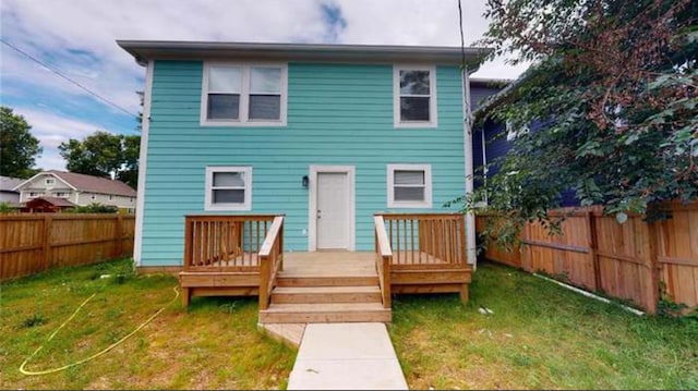 rear view of house with a yard and a deck