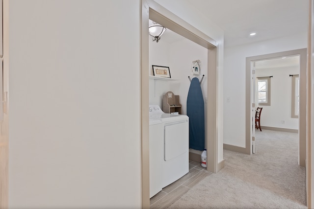 hallway with light carpet and washer and clothes dryer