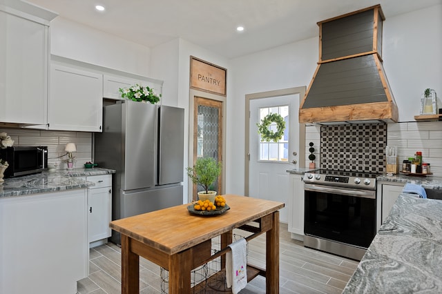 kitchen with white cabinetry, tasteful backsplash, stainless steel appliances, and light stone countertops