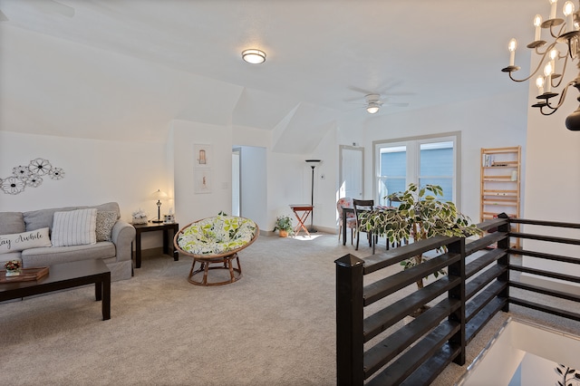 living room featuring light carpet, vaulted ceiling, and ceiling fan with notable chandelier