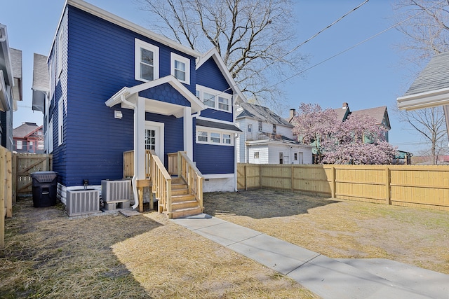 view of front of house featuring central AC unit and a front yard