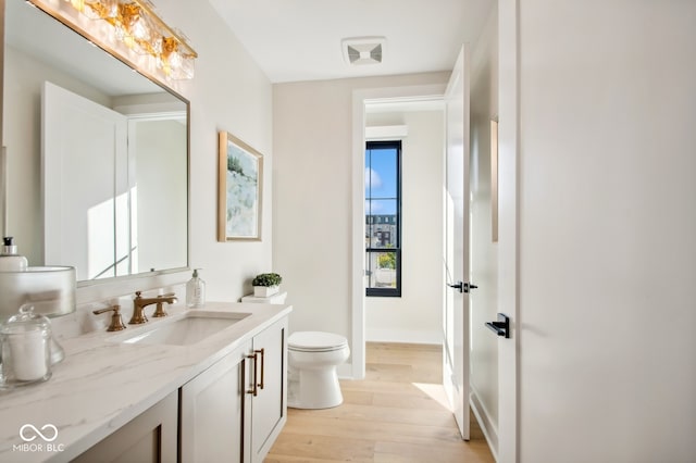 bathroom featuring vanity, hardwood / wood-style floors, and toilet