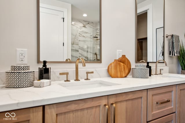 bathroom with a shower with shower door and vanity