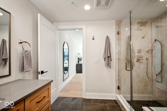 bathroom with hardwood / wood-style flooring, an enclosed shower, and vanity