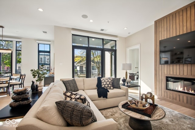 living room with a large fireplace, plenty of natural light, and hardwood / wood-style floors