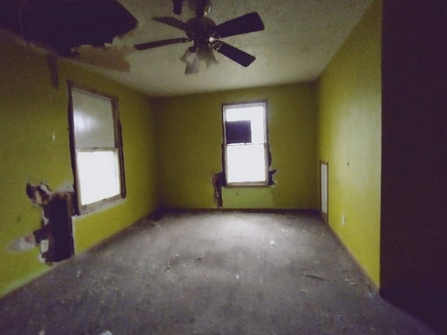 empty room featuring ceiling fan and a wealth of natural light