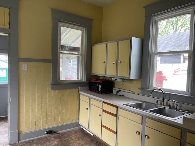 kitchen with sink, tile walls, and dark tile floors